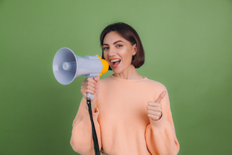 young-woman-casual-peach-sweater-isolated-green-olive-color-wall.jpg